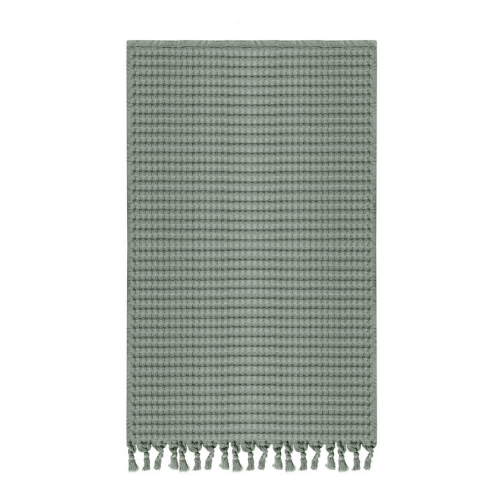 Waffle hand towel with decorative tassels on one end.