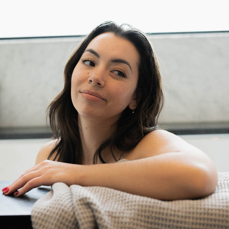 Waffle bath sheet draped on black marble bath tub.