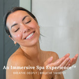 Woman in a shower using a Gilden Tree shower steamer to breathe deeply and breathe sweetly.